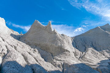 Beautiful view for weathered textured white limestone rock cliff mountain of quarry. Industrial, cosmic landscape. Concept environmental ecology, pollution.