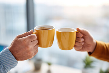 Cheers with yellow coffee mugs in a modern setting
