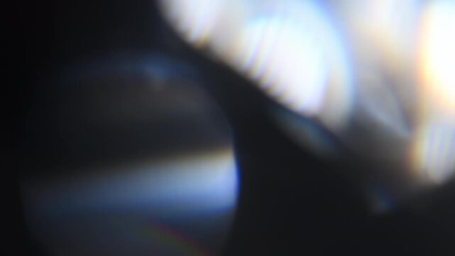 Retro style cinematic intro with large glowing lens flares, as if a diamond slowly spins in front of the camera. Sparkling light refractions create a classic, magical opening for titles and intros.