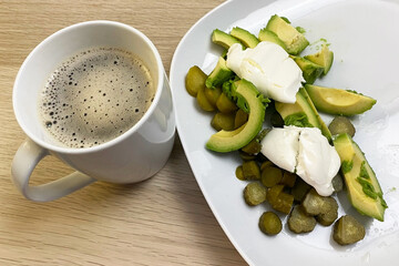 Healthy Breakfast with Coffee, Avocado, Poached Eggs, and Pickles