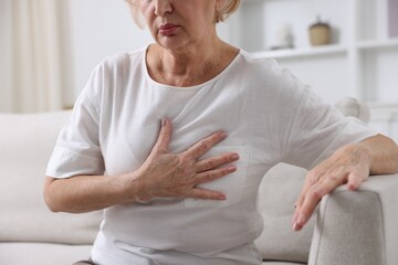 Heart attack. Senior woman suffering from pain in chest indoors, closeup
