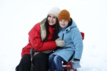 Happy mother and her son with sledge outdoors on winter day © New Africa