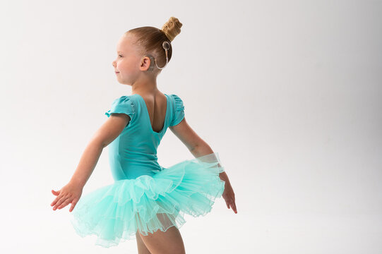 Little ballerina with cochlear implant dancing in turquoise tutu, copy space. Harmony of hearing technology, childhood grace, and inclusion through music and movement.