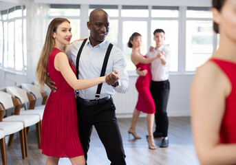 Fototapeta premium Couple of adult man and young woman dancing waltz in studio