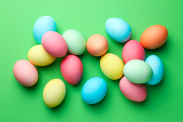 Beautiful decorated Easter eggs on green background, flat lay