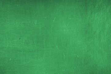 Drawing board with erase chalk marks on green chalkboard background, dusty smudges and soft streaks, classroom blackboard texture with space for text, education backdrop, horizontal photo.