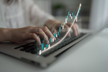 Hands typing on a laptop with a digital financial graph overlay, illustrating the concept of data analysis and investment growth in a modern business environment. Impute