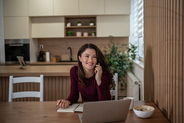 Woman multitasking working from home talking on phone