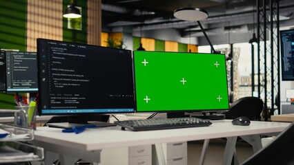 Green screen PC in empty startup office with programming language script running on monitors. Mockup computers in AI industry startup workspace leveraging coding software enhancing system automation