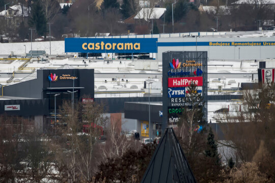 Polska, Ostrowiec Świętokrzyski, 31 grudnia 2025, 14:54. Centrum handlowe z widocznym szyldem Castoramy. Inne widoczne marki to KFC i Carrefour, co wskazuje na r&oacute;żnorodną ofertę handlową. 