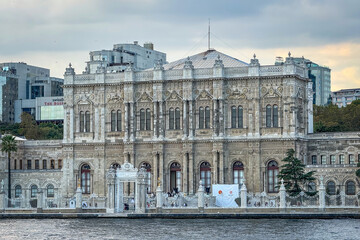 Fototapeta premium Symmetrical view of Dolmabahce Palace from the Bosphorus in Istanbul, Turkey, highlighting the ornate waterfront gate, marble facade and fence under soft light