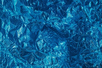 Macro texture of vibrant blue painted aluminum foil