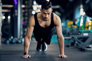 Handsome Middle Eastern Sporty Man Making Push Up Exercises On Floor At Gym, Young Muscular Arab...