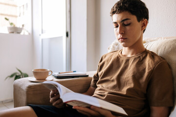 Teenager boy studying and reading at home