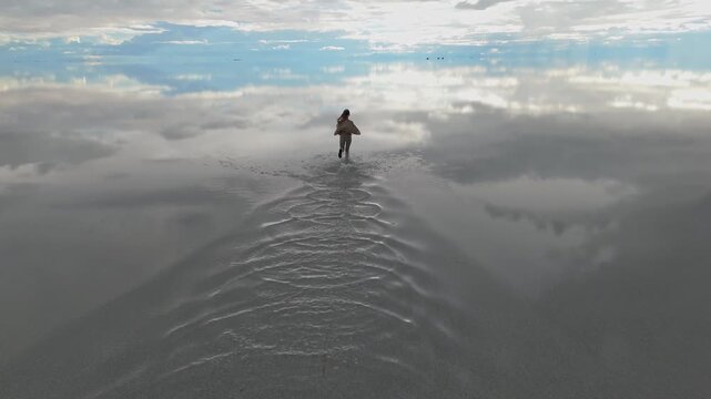 A solitary figure running across the expansive Salar de Uyuni in Bolivia, capturing the serene beauty of the world's largest salt flat