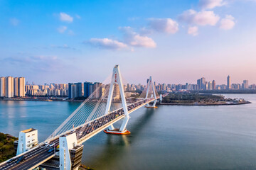 Obraz premium Aerial view of the skyline at dusk over the Haidian River Century Bridge in Haikou, Hainan Island, China.