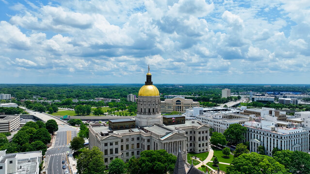 Photo taken in Atlanta, Georgia, USA on May 20, 2024. This aerial drone image captures the Georgia State Capitol Building rising prominently above downtown Atlanta, framed by bold white clouds 