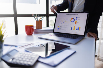 Business woman analyzing financial data using graphs and charts, developing corporate strategy during a meeting in a modern office
