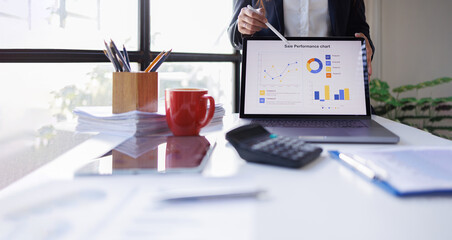 Business woman analyzing summary report data on laptop in modern office report graphics meeting at office
