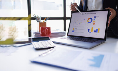 Business woman analyzing summary report data on laptop in modern office report graphics meeting at office
