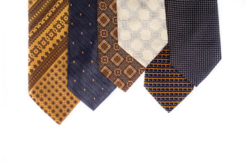 Assortment of men's neckties with different patterns isolated on a white background. Fashion accessories arranged diagonally with ample copy space for design.