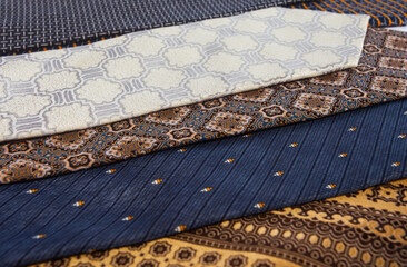 Full frame texture of colorful tie fabrics. Assortment of silk neckties with diverse motifs like stripes and batik, perfect for menswear fashion concepts