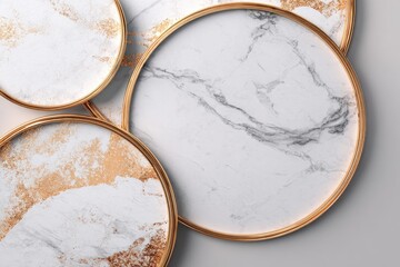Close-up of four overlapping circular surfaces with marbled texture and gold frames, against a soft, neutral background