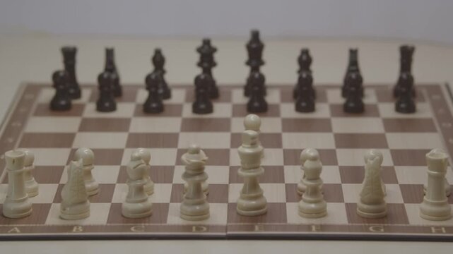 A cinematic shot of movement in a chess game. The first theoretical move is for White's pawn on e4