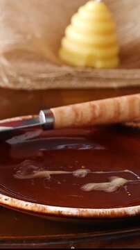 Spreading creamed honey on slice of bread and taking a bite
