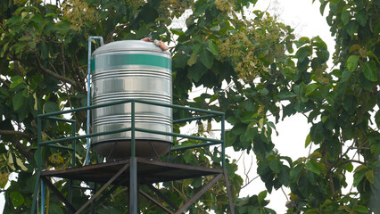 Stainless Steel Water Storage Tank on High Metal Tower in the Garden