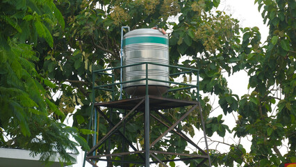 Stainless Steel Water Storage Tank on High Metal Tower in the Garden