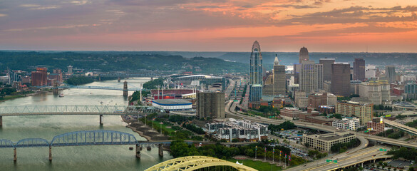 Cincinnati city, Ohio USA. View from above of brightly illuminated high skyscraper buildings in downtown district of American megapolis with business financial district at sunset