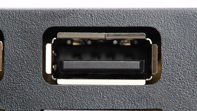 Extreme macro video of an USB Type-A female port socket on black electronic device panel, slow zoom-in on connector interface, computer hardware connection, data transfer technology detail, no people