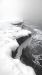 Icy coastal landscape showcasing a snow-covered cliff during a foggy winter season