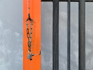 The padlock is attached to a chain and hung on the iron door.