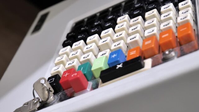 Vintage cash register keypad with round metal number buttons and inserted key, side view closeup detail of worn mechanical checkout machine, old retail payment and accounting concept background