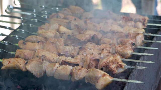 Traditional georgian mtsvadi, grill on the coals with smoke. Shashlik, barbecue. Slow motion