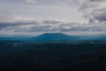 Obraz premium Distant Flat-Top Mountain Under Overcast Layered Sky