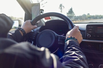 a man's hands on the steering wheel of a car
