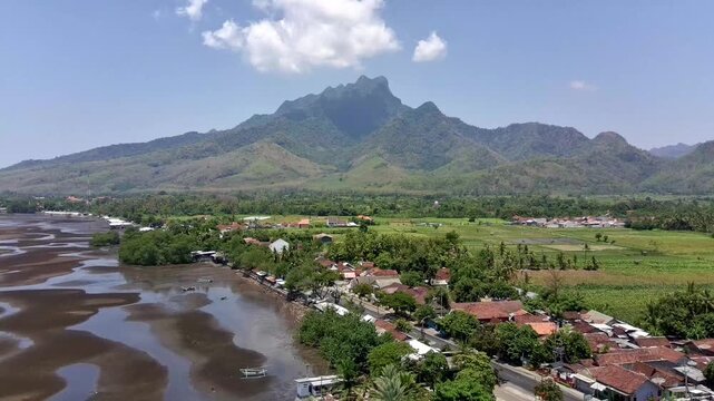 The coastline and north coast highway of East Java, passing through the Ringgit Mountains. Original 4K Aerial Drone daytime video.