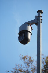 Security camera on pole under blue sky