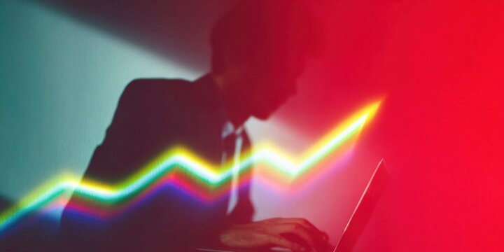 Businessman analyzing market growth trends using a glowing digital data chart and laptop computer in a dark office setting for 2025 financial planning and strategy - Powered by Adobe
