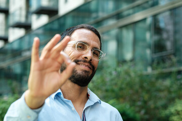 Obraz premium Businessman making ok sign in front of office building