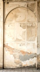 A worn, beige-colored wall with an arched doorway and peeling paint