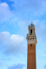 Naklejka premium Torre del Mangia historic bell tower on a sunny day in Italy
