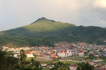 Obraz premium Panoramic view of Xamneua City in Houaphan Province, Laos, showcasing a beautiful city surrounded by green mountains and natural landscapes, known for its peaceful atmosphere and welcoming local commu