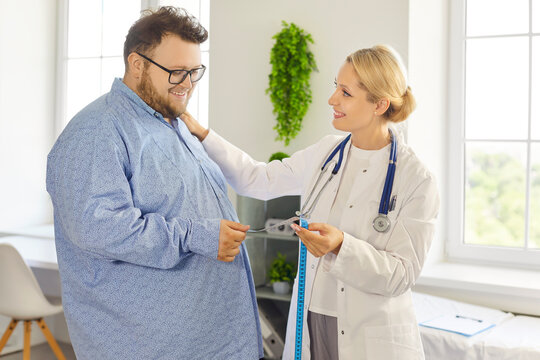 Female doctor and fat overweight patient in health consultation. Clinician holds a tape, discussing waist measurement, weight goals, and obesity risks in medical clinic. Medicine concept. 