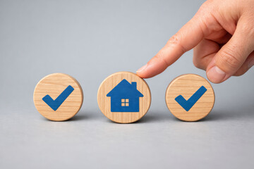 Confident hand choose property icon on wood block for important decision making about real estate investment