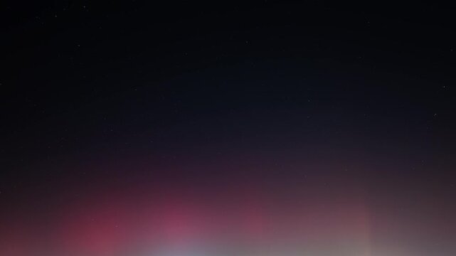 Northern lights in green and red color. Only the night sky with aurora borealis as time lapse video. Natural phenomenon as background footage. View from Germany, Europe during January.