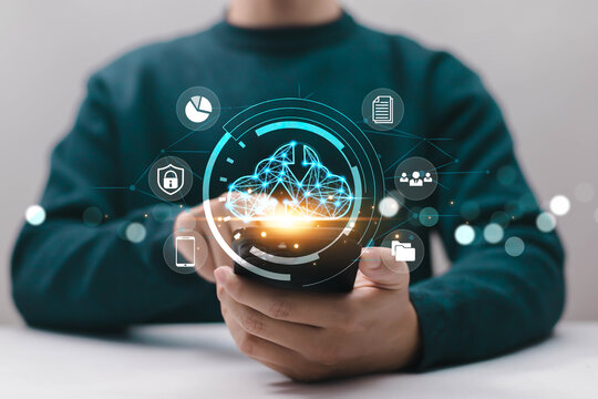 Person using smartphone with futuristic cloud computing interface and data icons, representing mobile cloud services, secure data storage, digital transformation, online connectivity, and technology. - Powered by Adobe